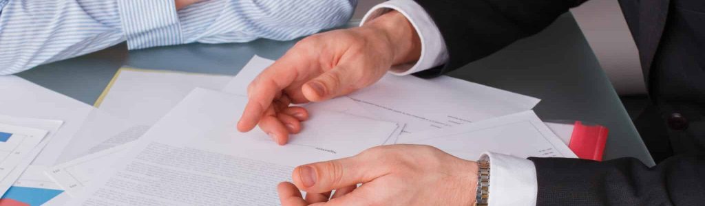 Businessman and business woman at business meeting. Businessman and business woman at business meeting. Business people discussing business papers.